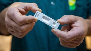 Un farmacéutico muestra un test de antígenos en una farmacia de Barcelona.