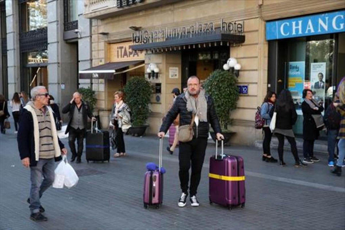 MENOS TURISTAS Unos huéspedes salen con sus maletas de un hotel. MENOS TURISTAS Unos huéspedes salen con sus maletas de un hotel.
