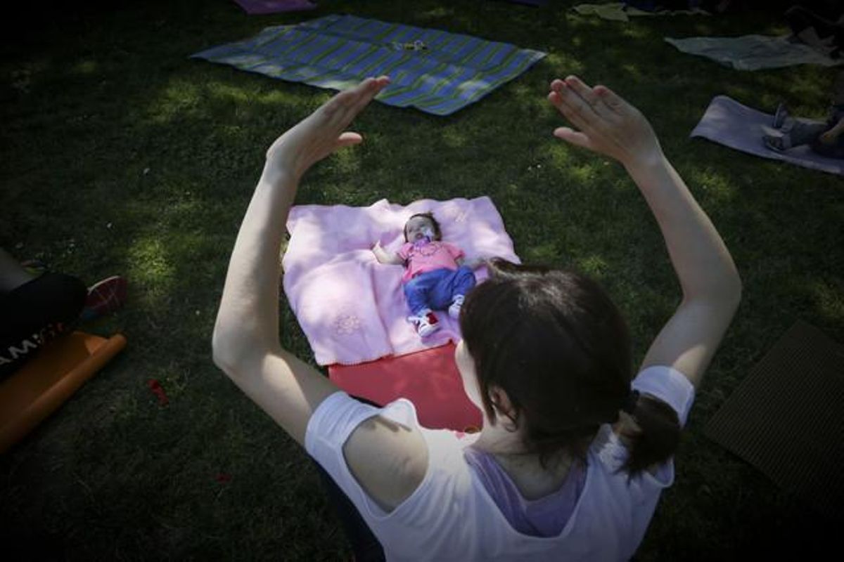 Una madre, con su bebé, hace gimnasia en un parque de Barcelona. Una madre, con su bebé, hace gimnasia en un parque de Barcelona.