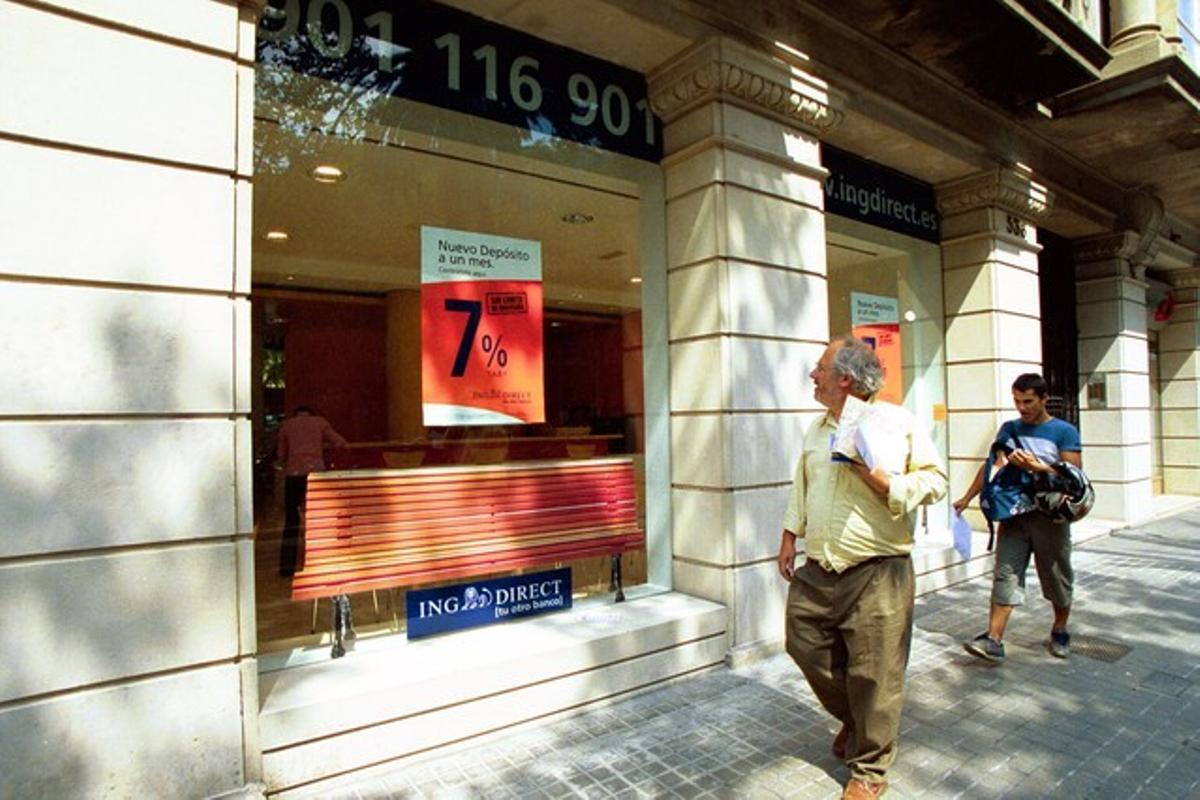 Dos personas pasan por delante de una oficina de ING Direct en Barcelona.