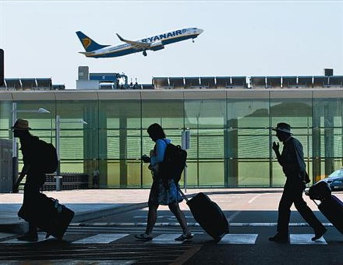 Despegue de un avión y trajín de pasajeros en el aeropuerto de El Prat, el pasado verano.