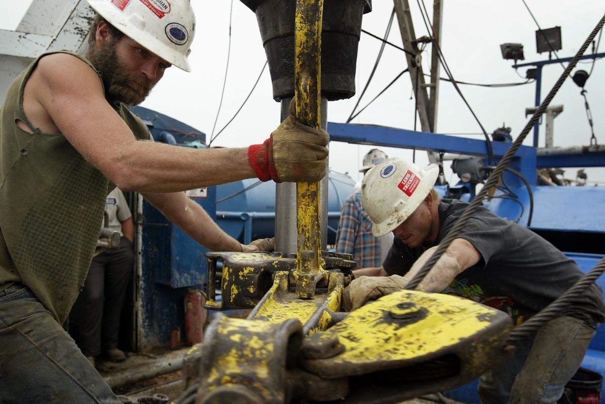 Jerry McKinney (L) y Jeremy Beck trabajan en una plataforma de perforación mientras buscan petróleo para Vintage Exploration, con sede en Houston, Texas.