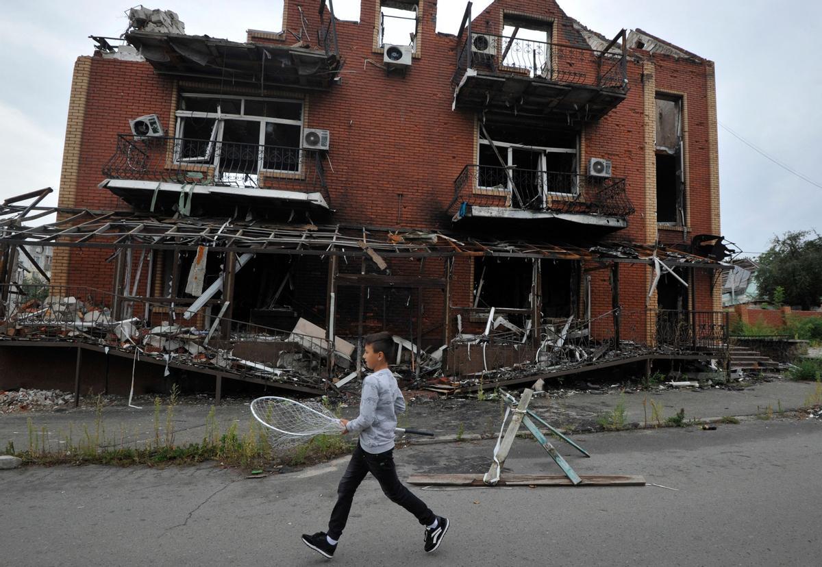 Un niño pasa junto a un edificio destruido en la región ucraniana de Kiev. 