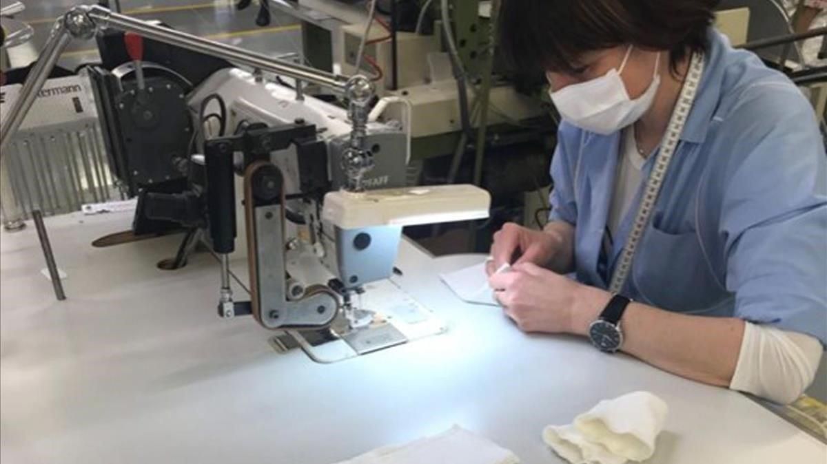 Una empleada de la empresa Armani trabaja en la elaboración de batas sanitarias en Verona. Una empleada de la empresa Armani trabaja en la elaboración de batas sanitarias en Verona.