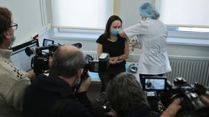 Unos periodistas presentes cuando una mujer recibe un pinchazo mientras le inyectan la vacuna Sputnik V.