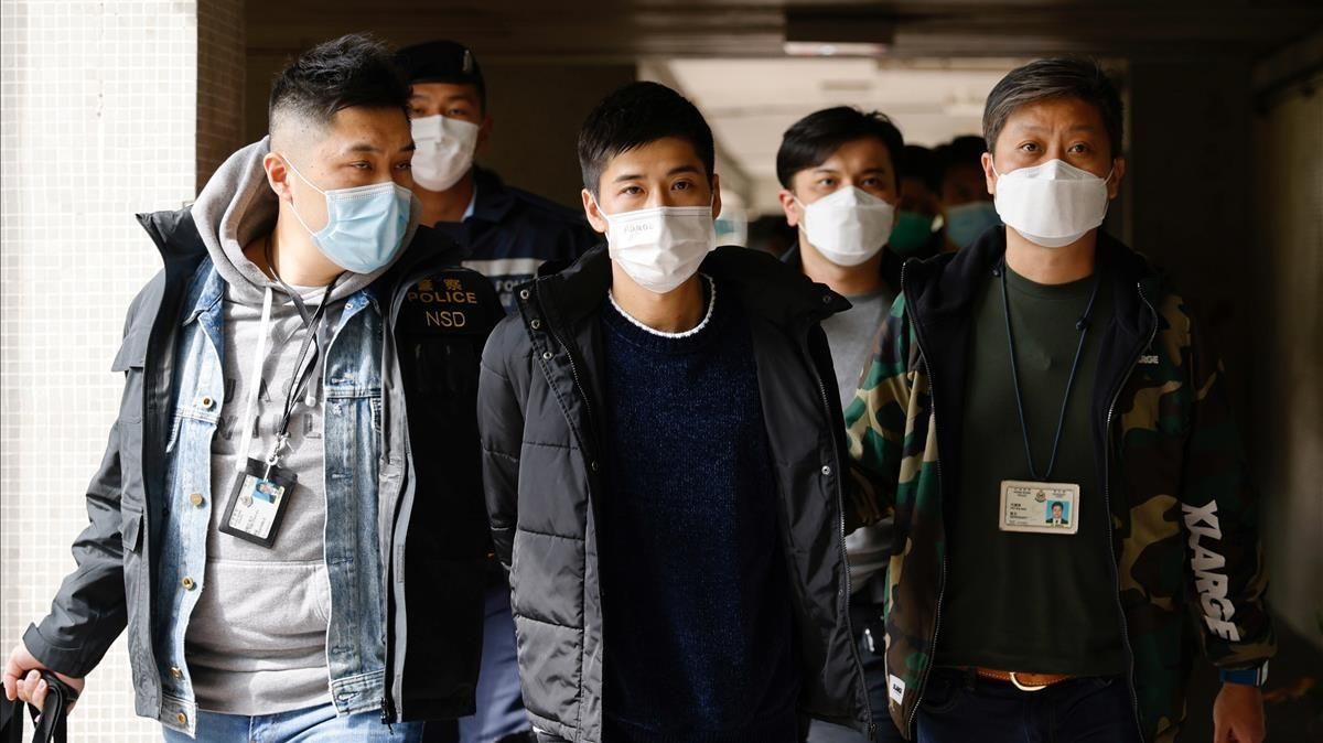 El activista Lester Shum, rodeado de policías durante su detención este lunes en Hong Kong. El activista Lester Shum, rodeado de policías durante su detención este lunes en Hong Kong.