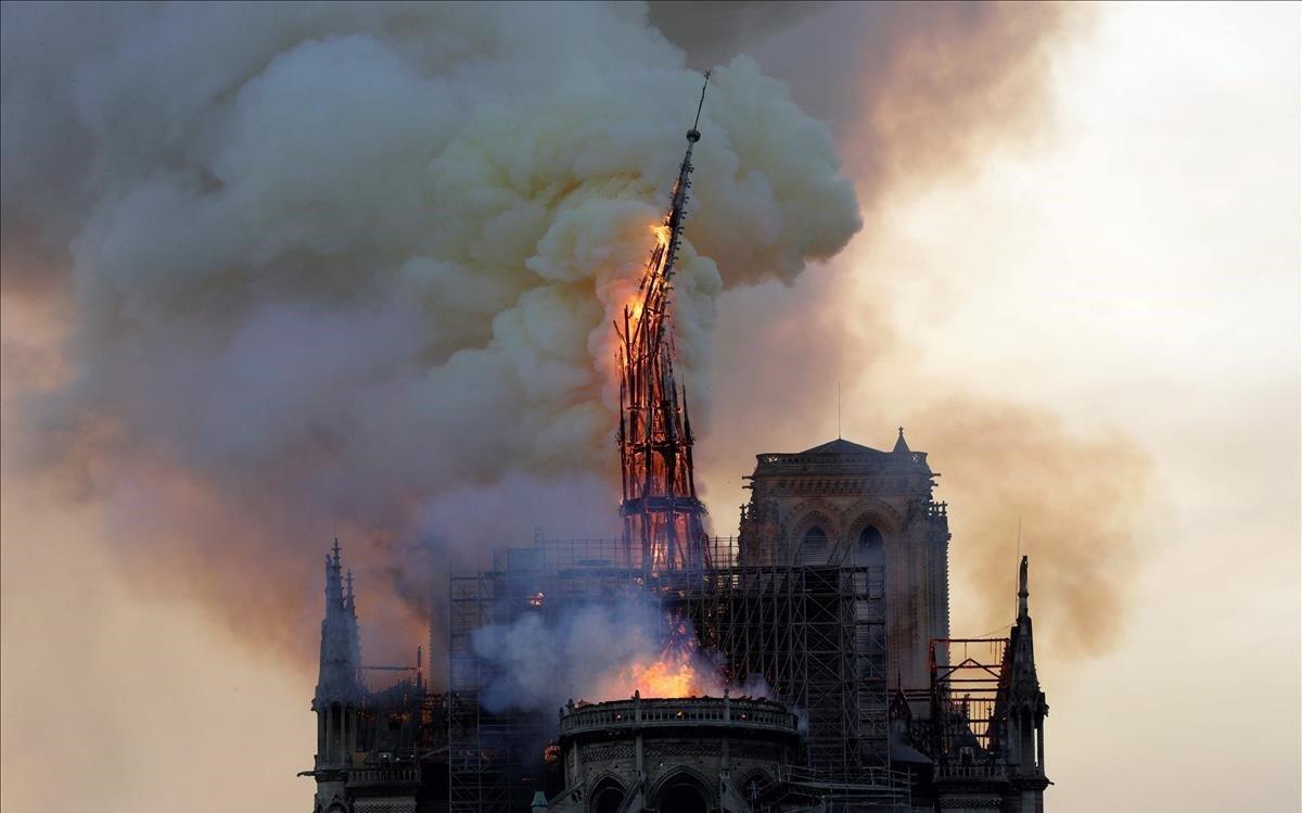 La aguja de la histórica catedral de Notre-Dame se derrumba.