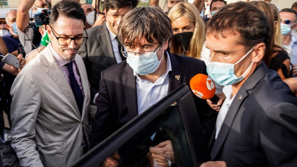 Exiled former Catalan president Carles Puigdemont (C) gets into a car as he leaves after being released from jail on September 24, 2021 in Sassari, Sardinia island, Italy. - Exiled former Catalan president Carles Puigdemont, who was arrested in Sardinia on September 23, 2021 at Spain’s request, was free to leave the country and his lawyer said Puigdemont would attend the next hearing in his extradition fight, on October 4, 2021. (Photo by Gianni BIDDAU / AFP)