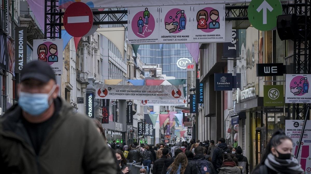 Ciudadanos con mascarila pasean por una calle comercial de Brusleas, este miércoles. Ciudadanos con mascarila pasean por una calle comercial de Brusleas, este miércoles.