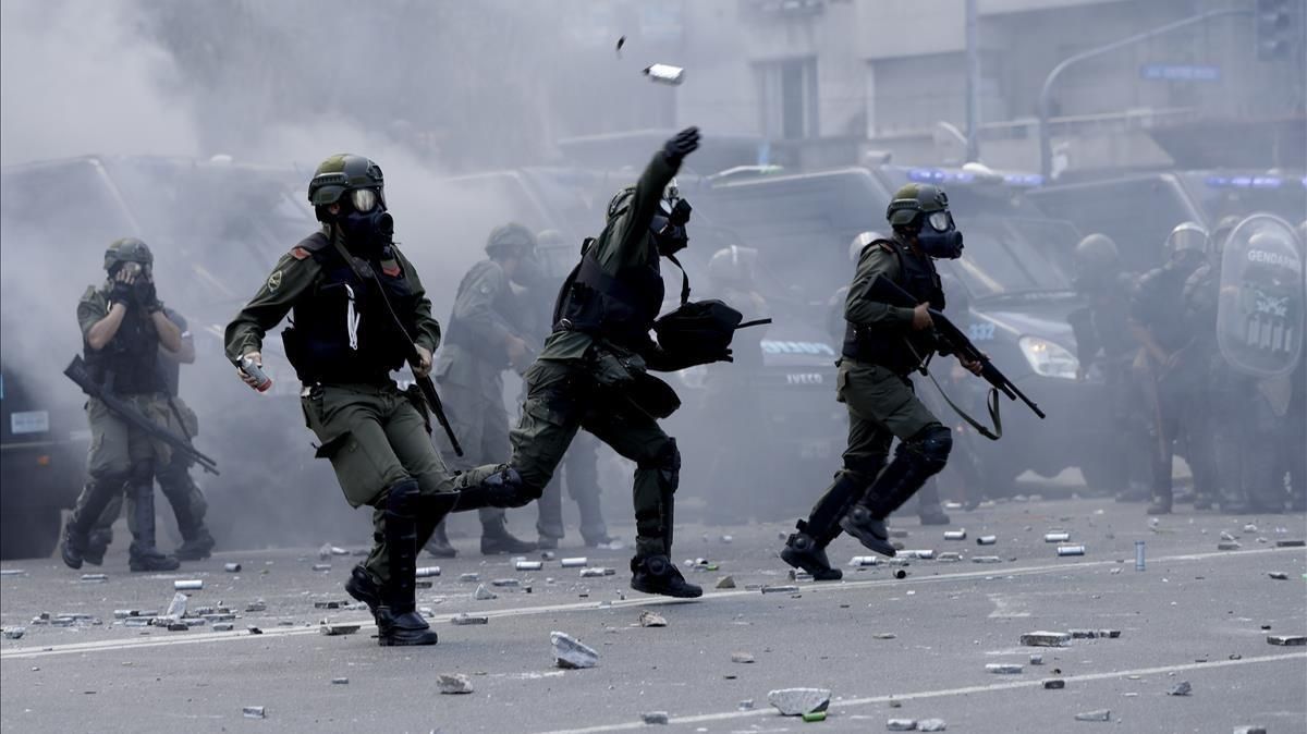 Policías lanzan botes de gas lacrimógeno contra los manifestantes que les lanzaron piedras y latas en las inmediaciones del Congreso, en Buenos Aires, el 14 de diciembre. Policías lanzan botes de gas lacrimógeno contra los manifestantes que les lanzaron piedras y latas en las inmediaciones del Congreso, en Buenos Aires, el 14 de diciembre.