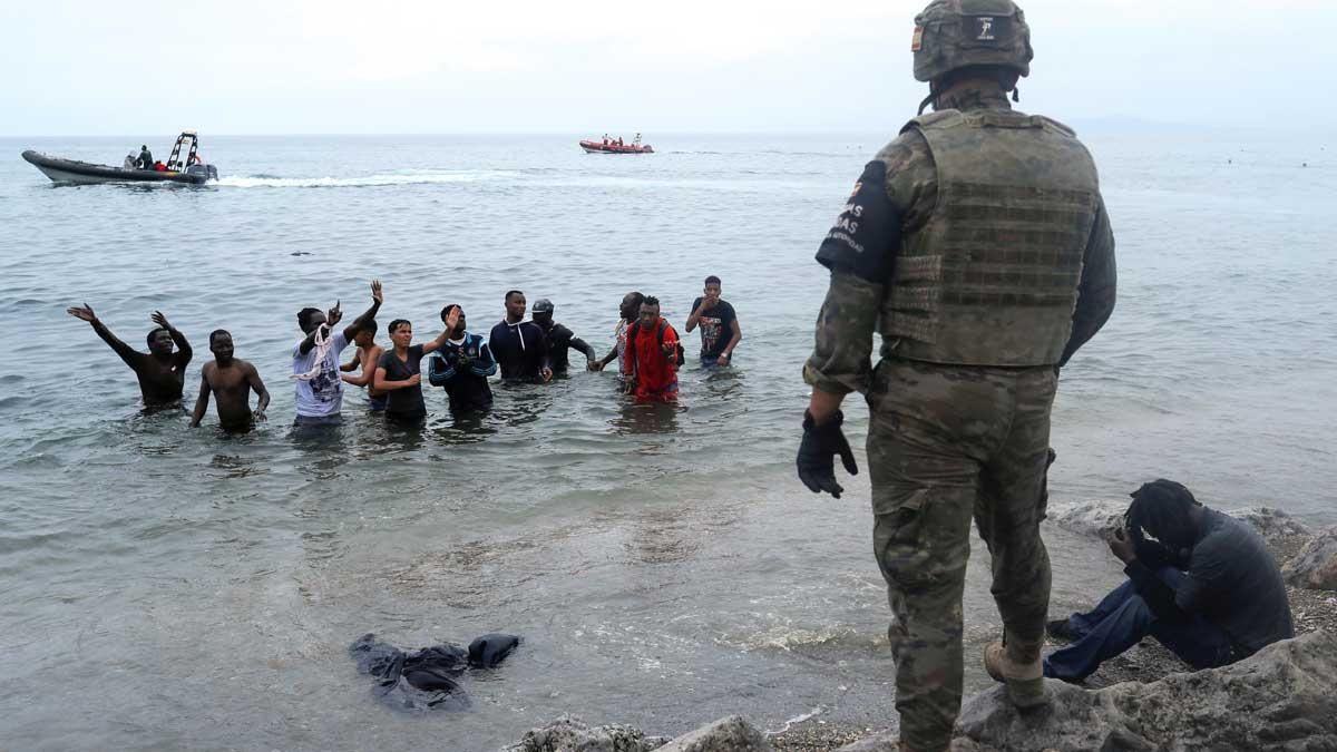 Un legionario español, frente a ciudadanos marroquís que intentaron entrar a nado a España cruzando la frontera en Ceuta. Un legionario español, frente a ciudadanos marroquís que intentaron entrar a nado a España cruzando la frontera en Ceuta.