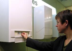 Una mujer prueba una caldera de gas de calefacción y agua caliente.