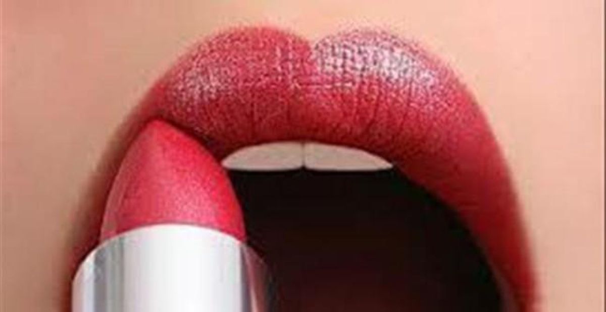 Una mujer pintándose los labios. Una mujer pintándose los labios.