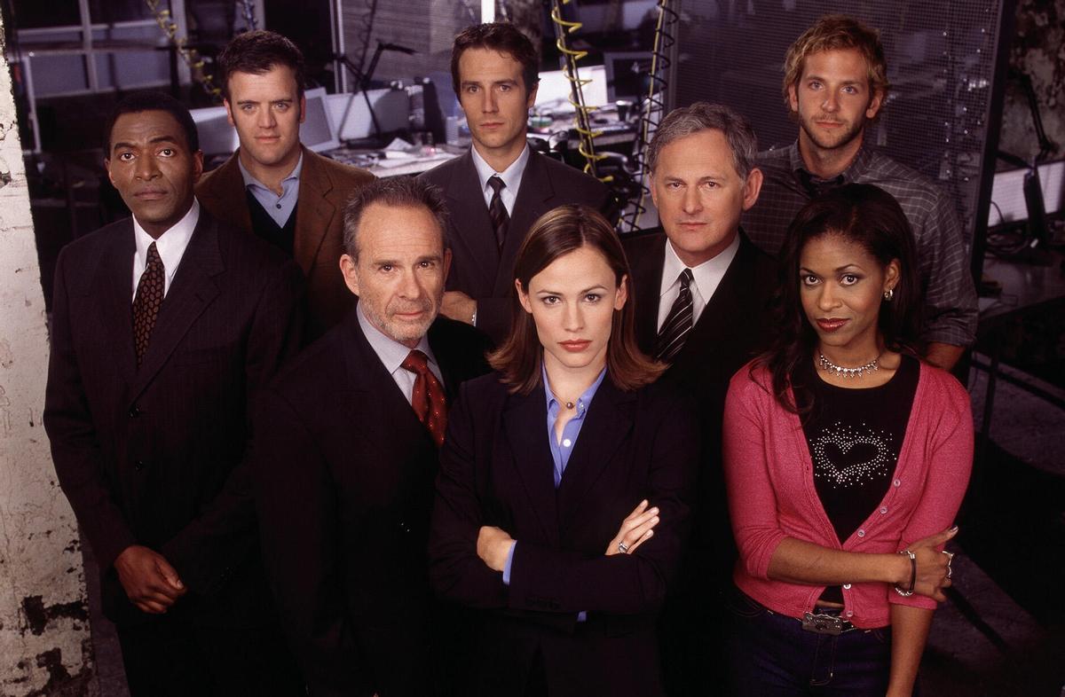 Foto de grupo del reparto de ’Alias’, con Jennifer Garner delante, en el centro (y un joven Bradley Cooper en la esquina superior derecha).