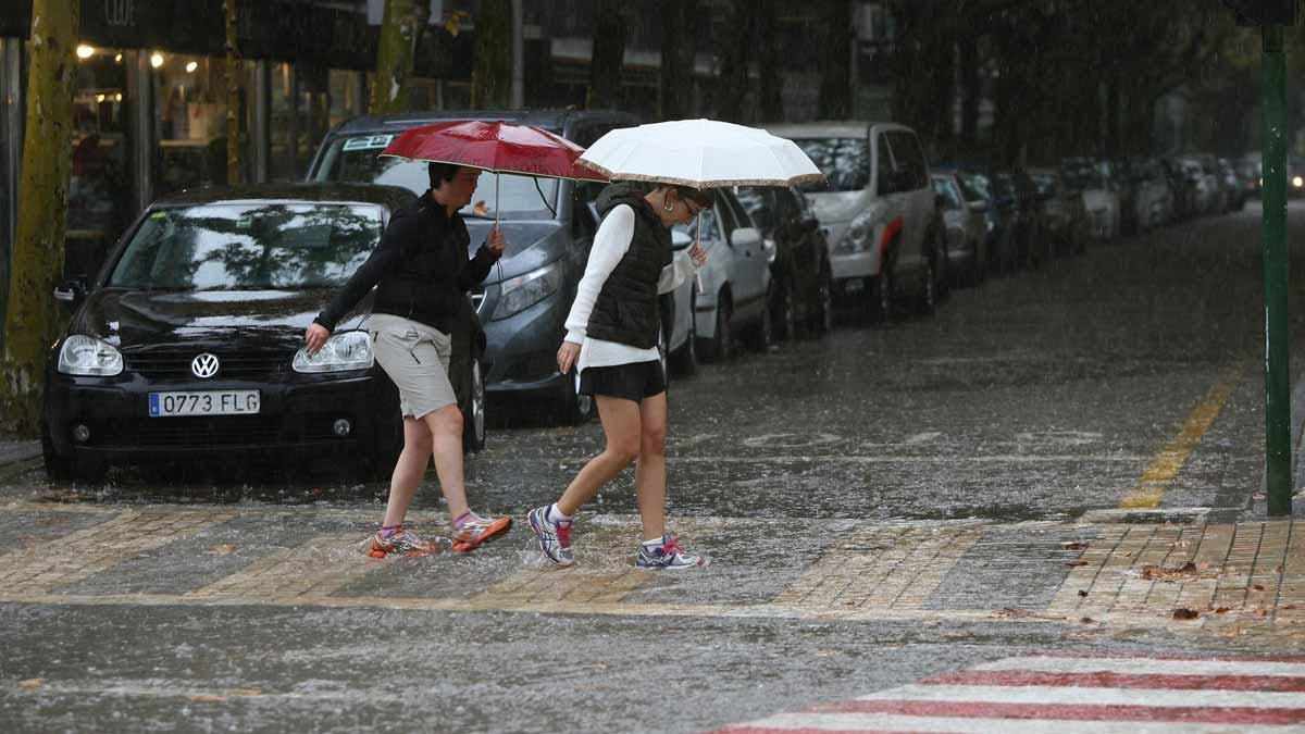 Unas mujeres cruzan la calle en un día de lluvia en Salou. Unas mujeres cruzan la calle en un día de lluvia en Salou.