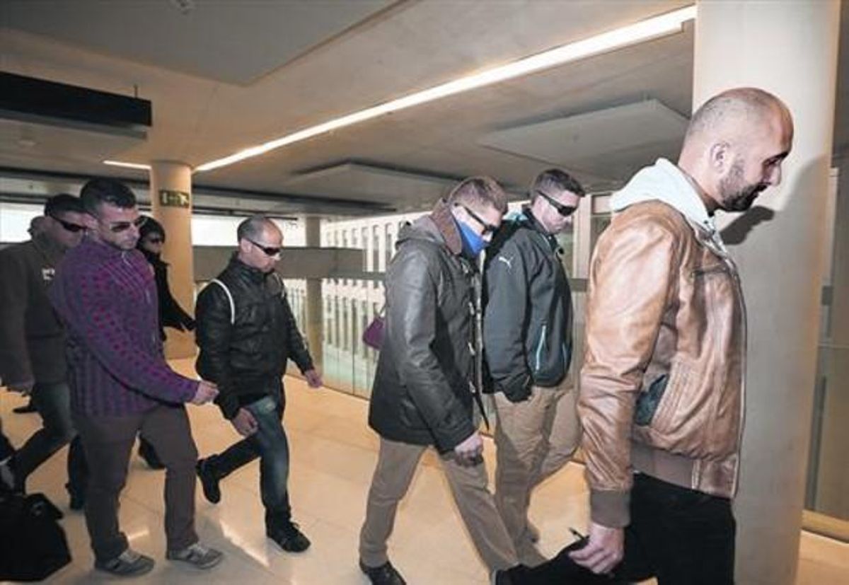 Un grupo de mossos acompañan a uno de los imputados, en la Ciutat de la Justícia. Un grupo de mossos acompañan a uno de los imputados, en la Ciutat de la Justícia.