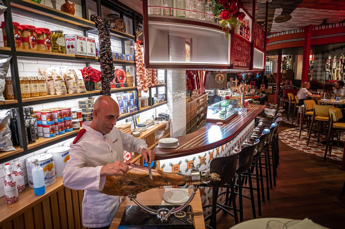 Un camarero corta jamón en el nuevo restaurante Tracatrá, junto a la plaza de Catalunya.