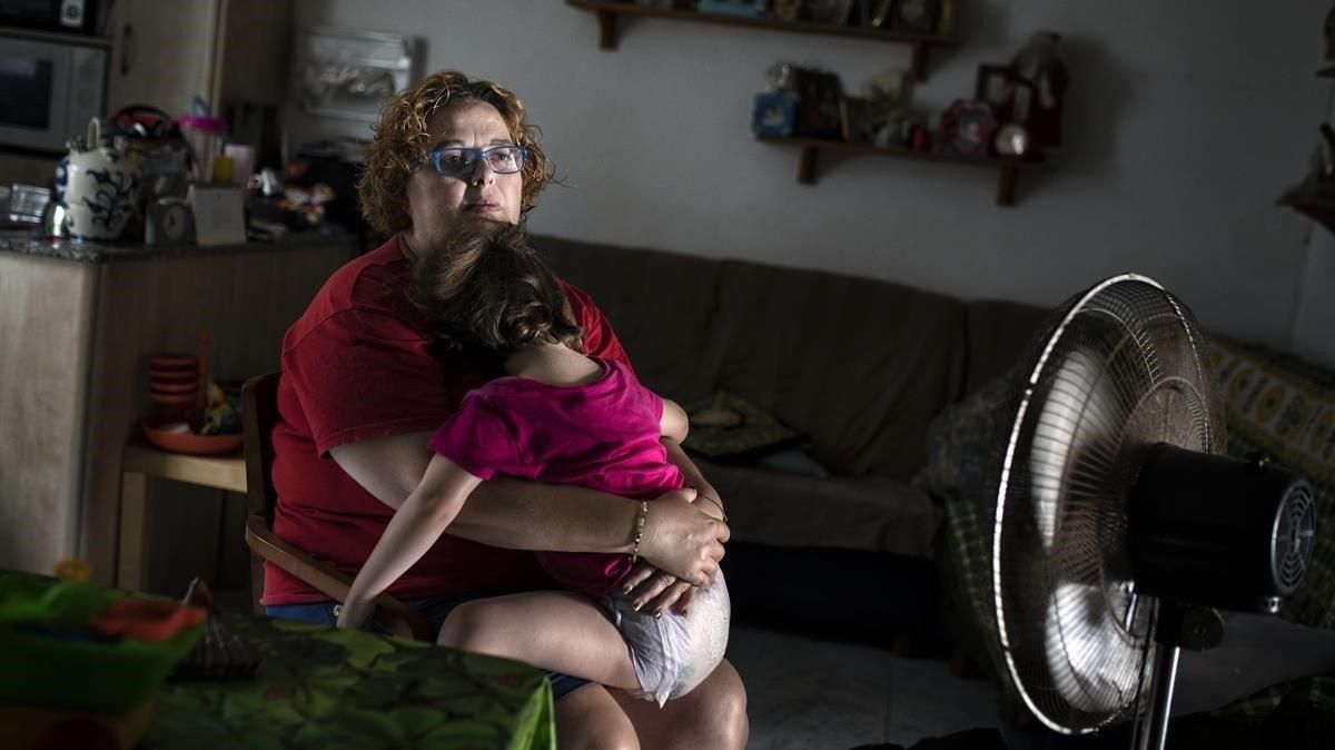 Cristina García, vecina de Badalona y víctima de la pobreza energética, este verano junto a su hija más pequeña. Cristina García, vecina de Badalona y víctima de la pobreza energética, este verano junto a su hija más pequeña.