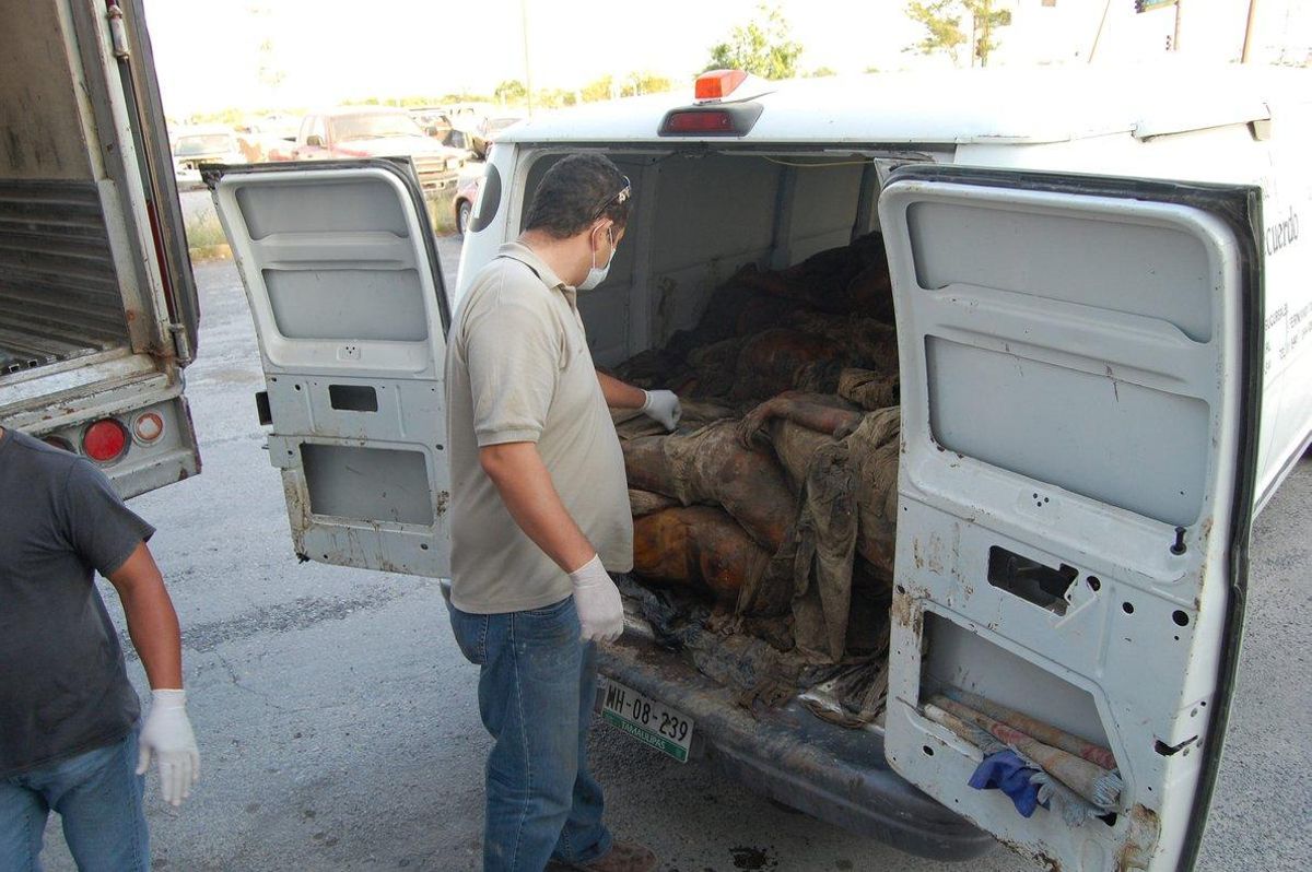 Peritos forenses descargan uno de los cadáveres hallados en las fosas clandestinas encontradas en Veracruz. Peritos forenses descargan uno de los cadáveres hallados en las fosas clandestinas encontradas en Veracruz.