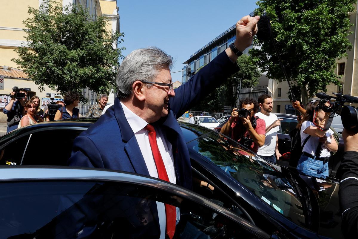 El líder de la Francia Insumisa, Jean-Luc Mélenchon, alza el brazo tras votar en un colegio electoral de Marsella, este domingo.