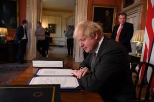 El primer ministro británico Boris Johnson firma el acuerdo comercial del Brexit con la UE en Downing Street en Londres, Gran Bretaña, el 30 de diciembre de 2020. 