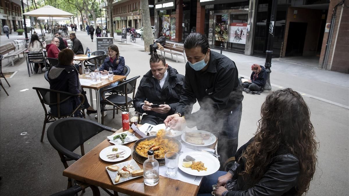 Un camanero sirve una paella en la terraza de un restaurante de la Rambla del Poblenou este pasado mes de abril. Un camanero sirve una paella en la terraza de un restaurante de la Rambla del Poblenou este pasado mes de abril.