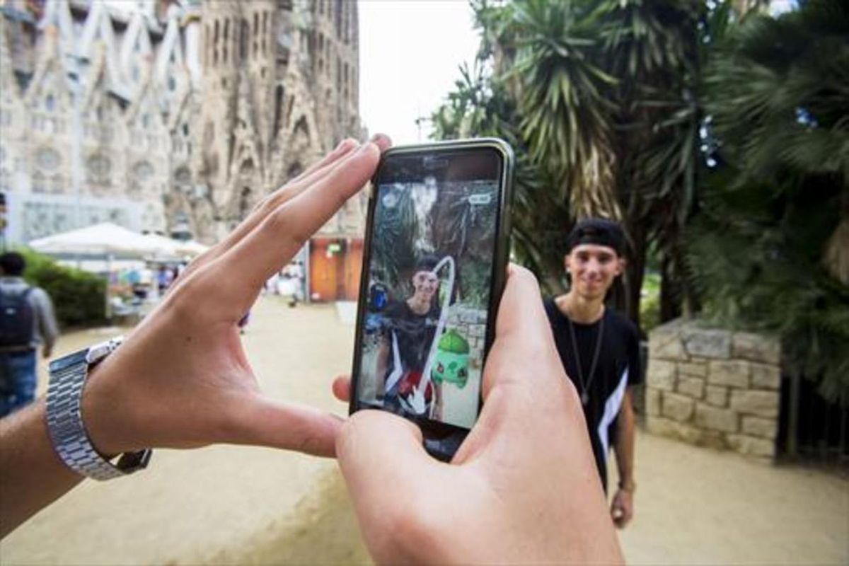 Dos usuarios de Pokémon Go frente a la Sagrada Família. Dos usuarios de Pokémon Go frente a la Sagrada Família.