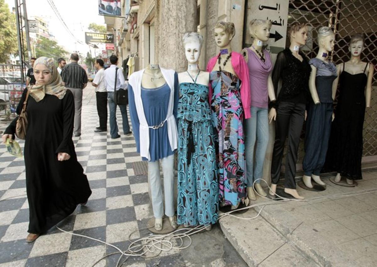 Una mujer palestina pasa junto a unos maniquís colocados en la calle, hoy en Gaza.