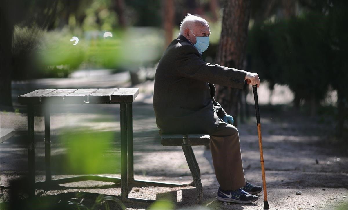 Un anciano con mascarilla, en un parque de Madrid, este viernes.