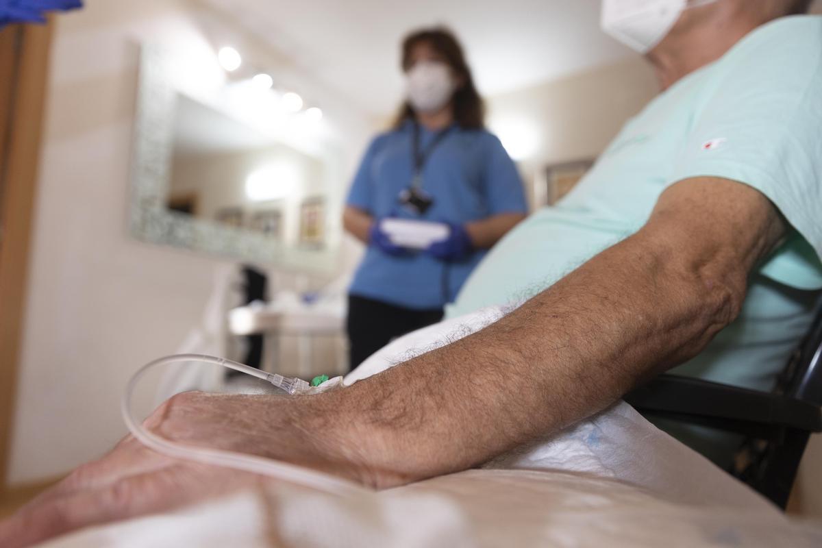 Una enfermera del Clínic atiende a un paciente que está en hospitalización domiciliaria.