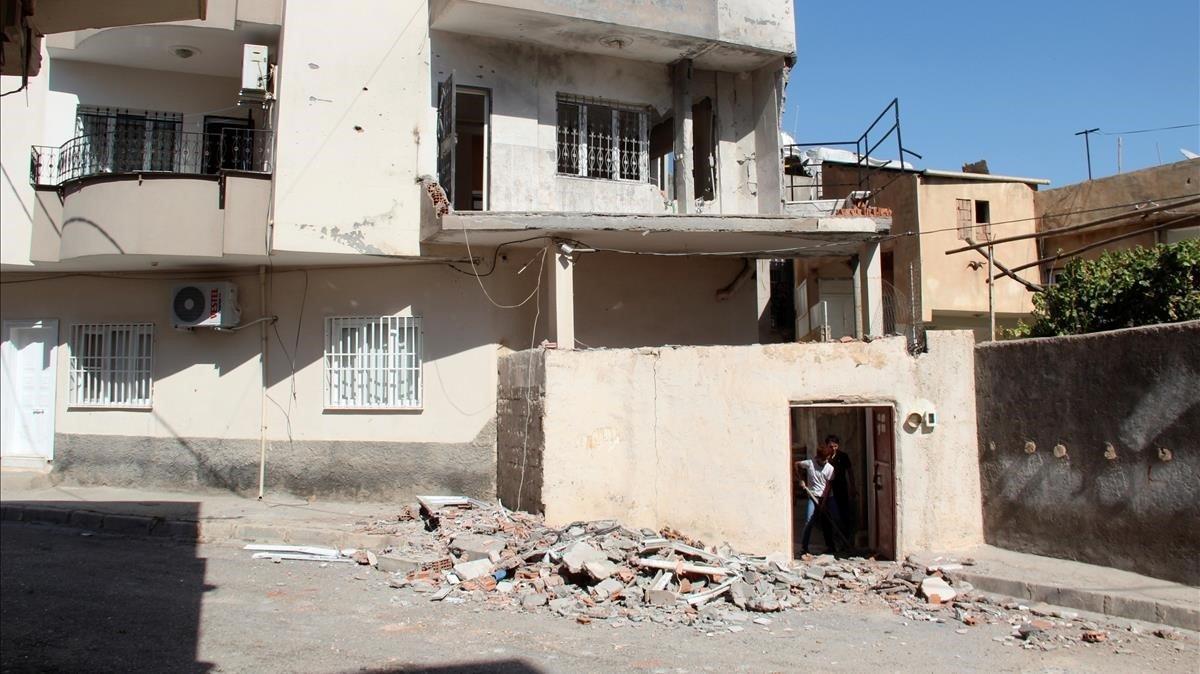 Un vecino limpia escombros en su casa de Nusaybin tras un ataque con morteros desde Siria, el pasado lunes.
