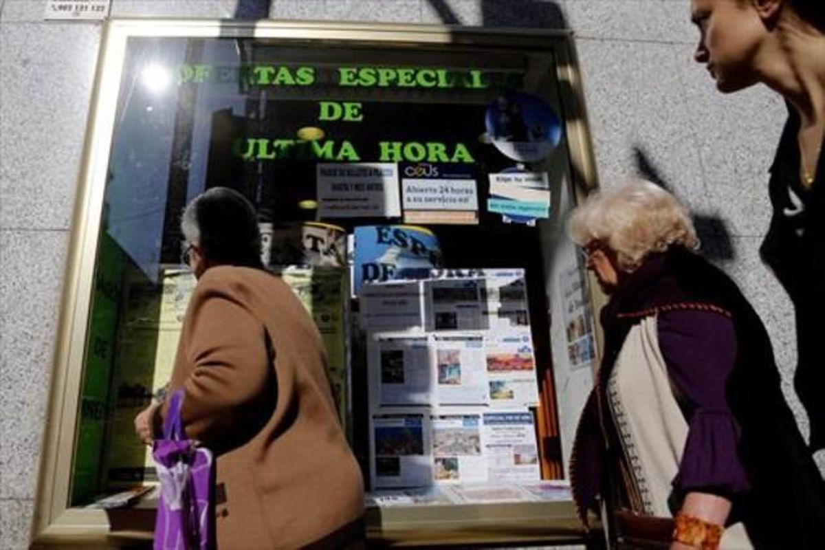 Varias personas miran el escaparate de una agencia de viajes, en Madrid. Varias personas miran el escaparate de una agencia de viajes, en Madrid.