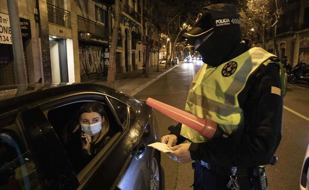 Un agente de la Guàrdia Urbana identifica a unas personas que circulaban por Barcelona fuera del horario permitido sin justificación. Un agente de la Guàrdia Urbana identifica a unas personas que circulaban por Barcelona fuera del horario permitido sin justificación.