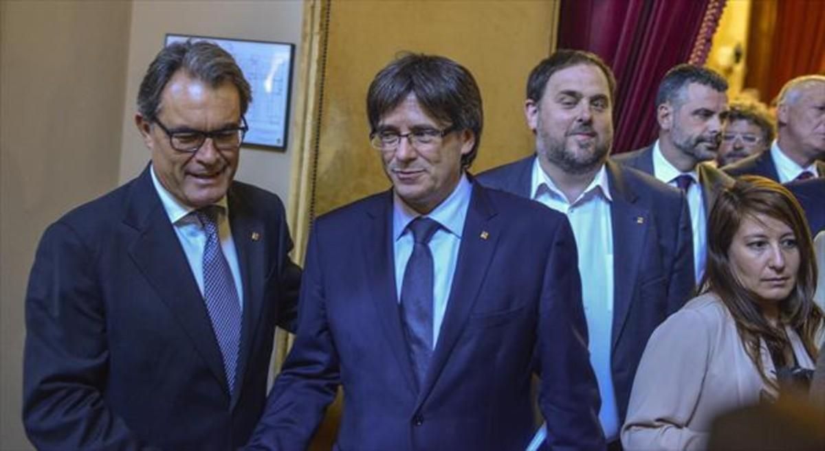 Mas saluda a Puigdemont ante la mirada de Junqueras en el Parlament tras la sesión sobre la moción de confianza. Mas saluda a Puigdemont ante la mirada de Junqueras en el Parlament tras la sesión sobre la moción de confianza.