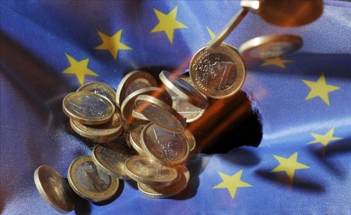 Un puñado de monedas de euro sobre la bandera de la Unión Europea. Un puñado de monedas de euro sobre la bandera de la Unión Europea.