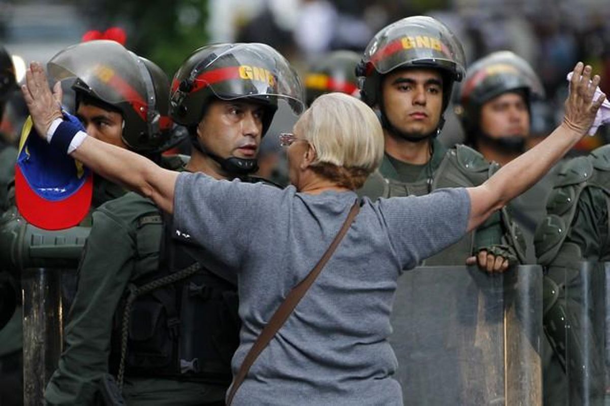 Una manifestante de la oposición se encara con la policía durante una protesta contra el Gobierno de Maduro, el lunes en Caracas. Una manifestante de la oposición se encara con la policía durante una protesta contra el Gobierno de Maduro, el lunes en Caracas.