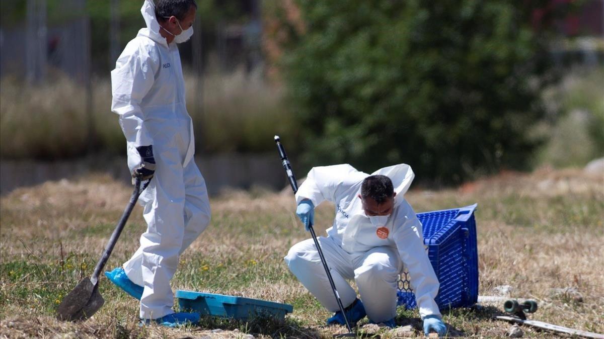 Miembros de la policía científica de los Mossos buscan pruebas en el solar de El Prat donde apareció el cadáver.