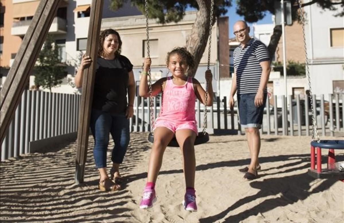 Erika Valero, jugando en un parque de Badalona, con sus padres.