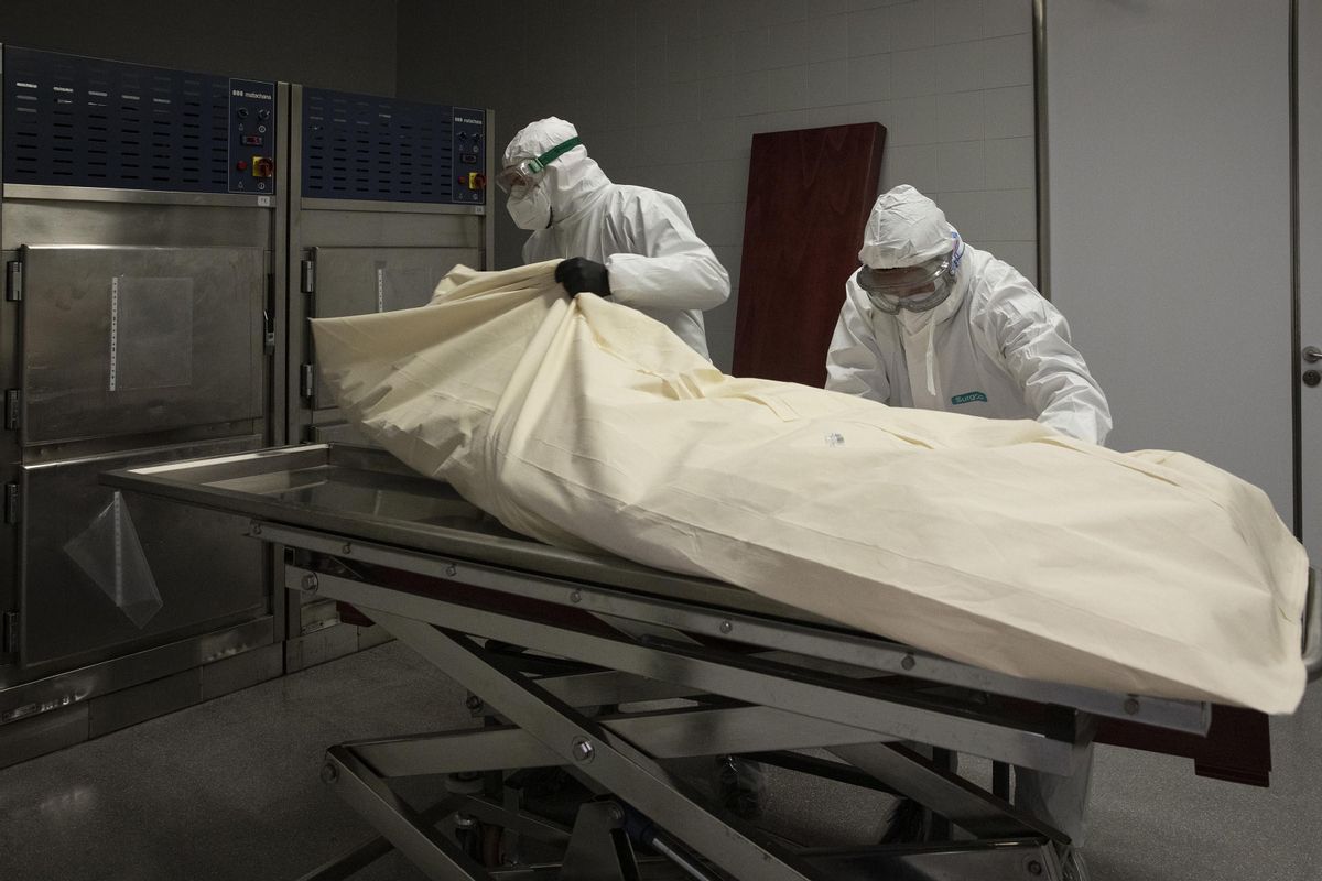 Dos operarios una funeraria preparan el entierro de un fallecido por covid. Dos operarios una funeraria preparan el entierro de un fallecido por covid.