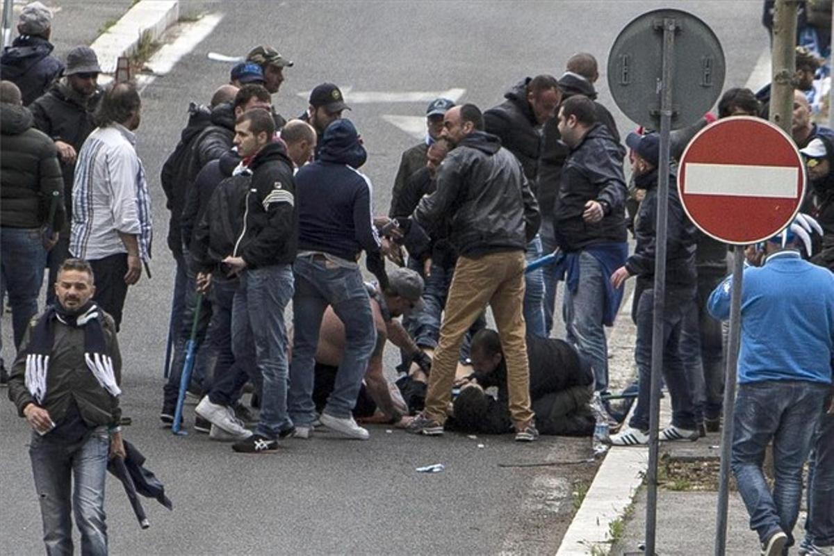 Uno de los herido de bala permanece en el suelo rodeado de otros seguidores del Nápoles.