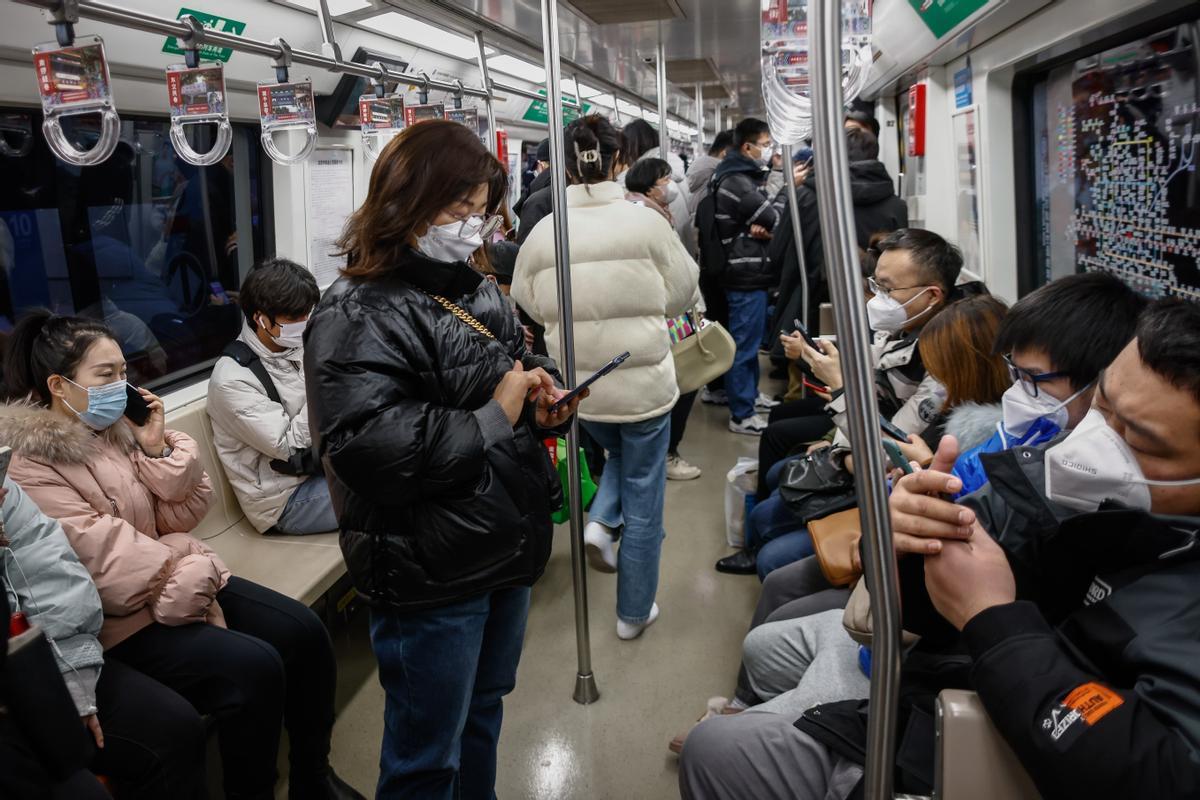 Personas usan máscaras faciales dentro de un tren en Beijing.Los científicos han advertido a China que el país enfrentará múltiples oleadas de infecciones por COVID-19.