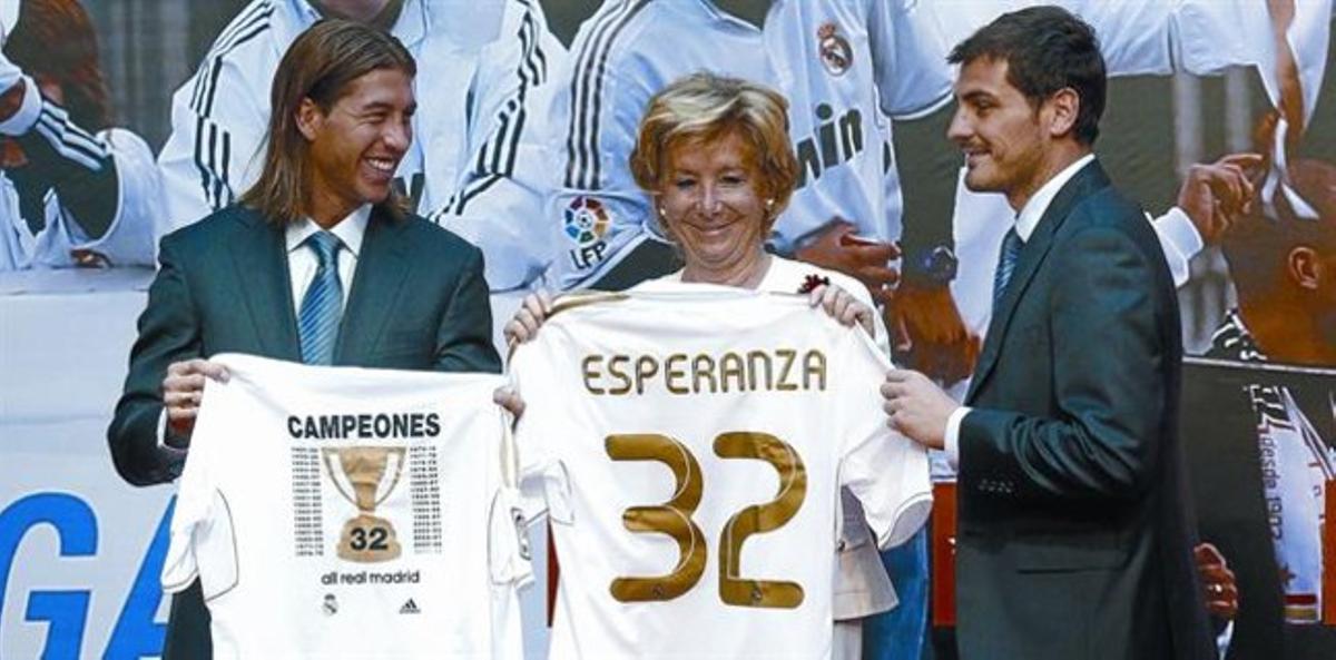 Esperanza Aguirre, madridista confesa, celebra exultante el reciente título de Liga conseguido por el Real Madrid, flanqueada por Sergio Ramos e Iker Casillas.