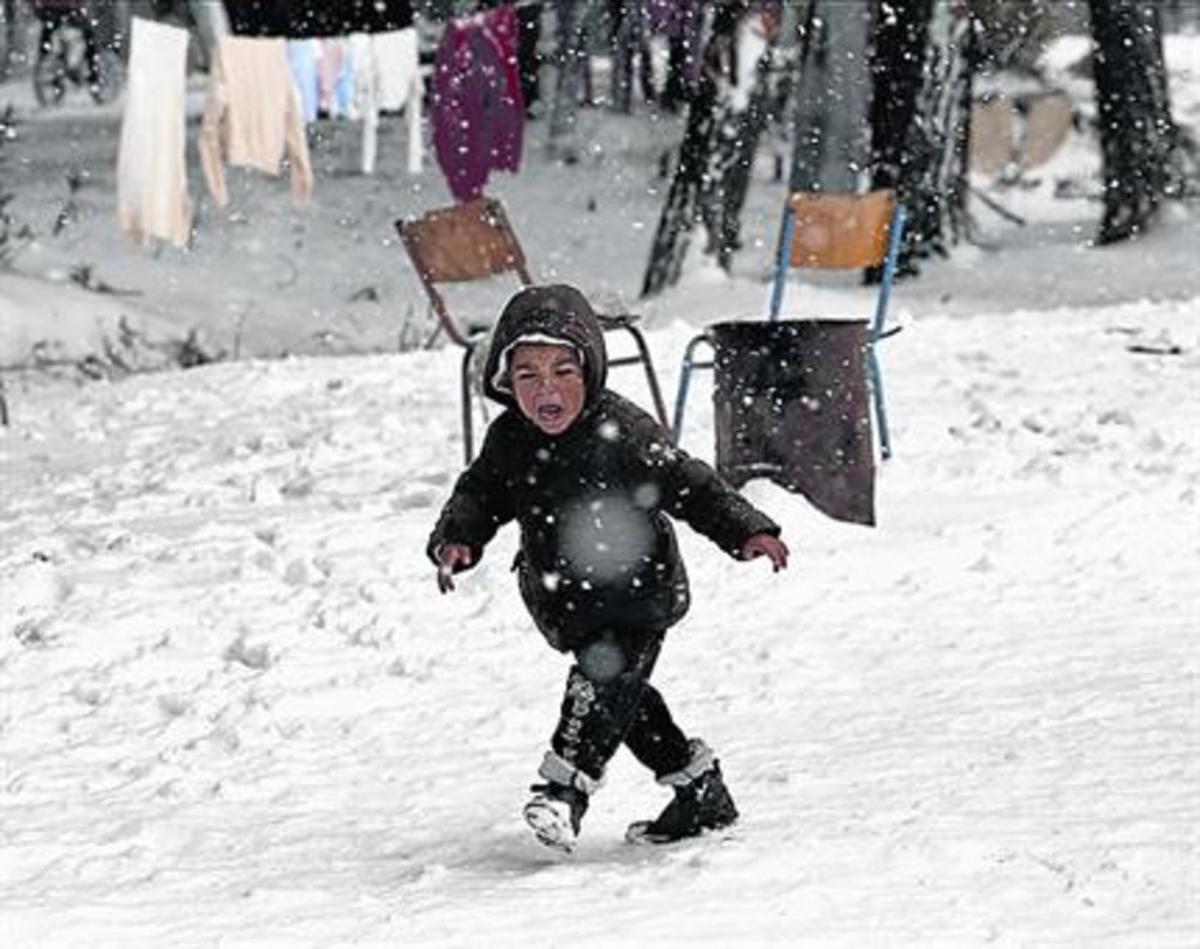 Un niño sirio, en un campo de refugiados lleno de nieve cerca de Atenas.