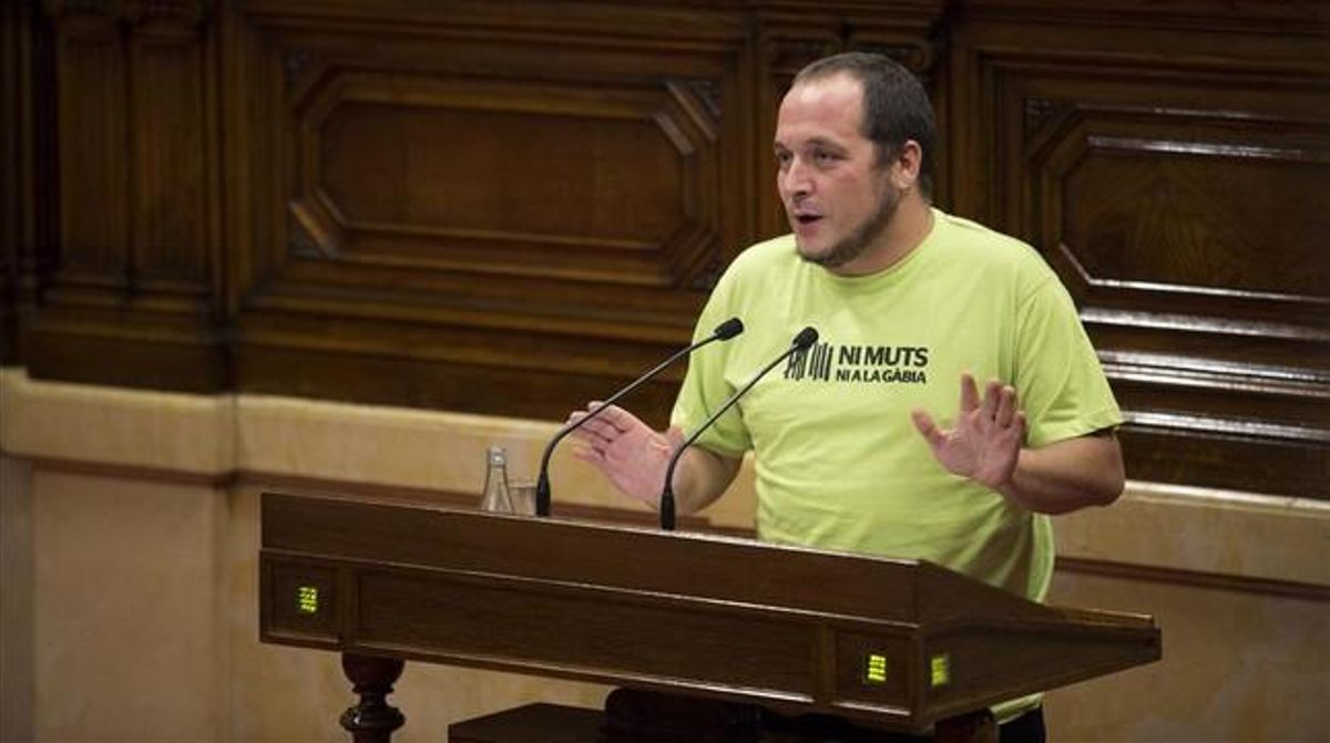 David Fernàndez, con una camiseta con el lema ’Ni muts ni a la gàbia’, en el pleno del Parlament del 2 de octubre del 2014. David Fernàndez, con una camiseta con el lema ’Ni muts ni a la gàbia’, en el pleno del Parlament del 2 de octubre del 2014.