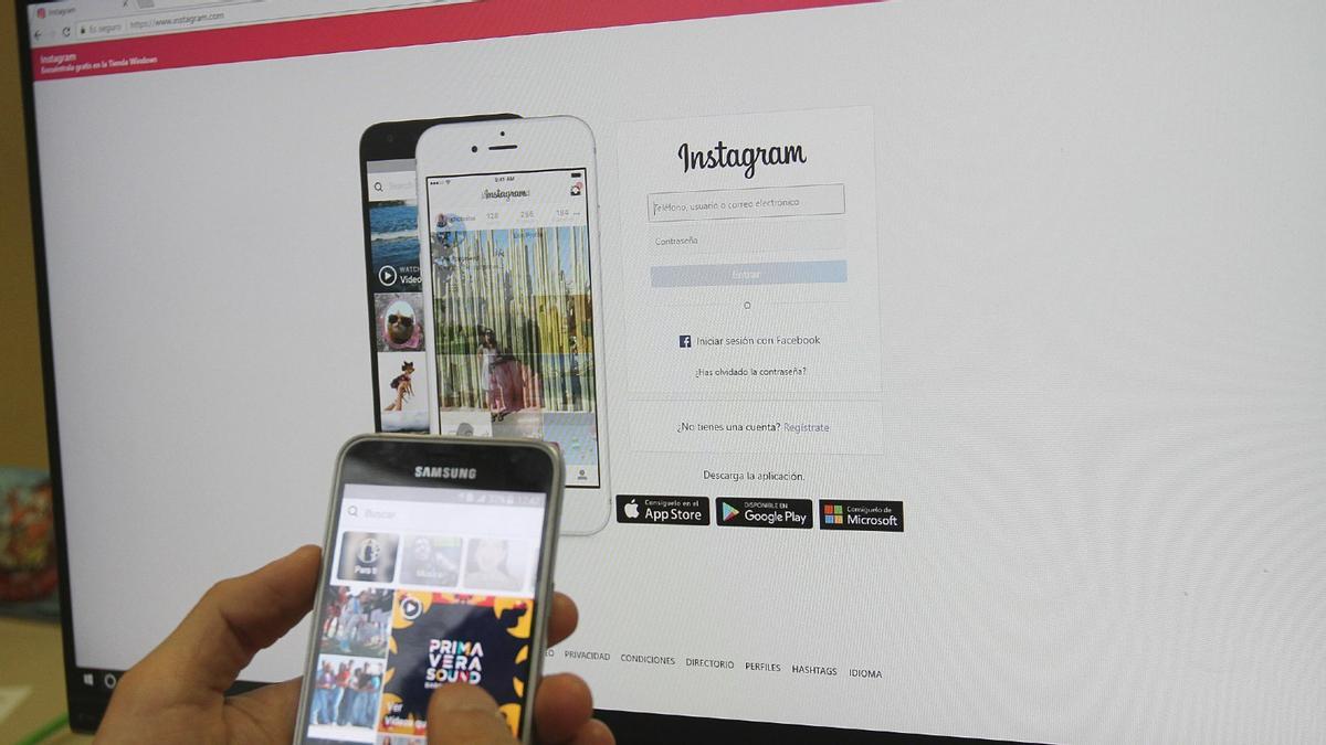 Una persona mira perfiles de Instagram en el móvil y en el ordenador. Una persona mira perfiles de Instagram en el móvil y en el ordenador.