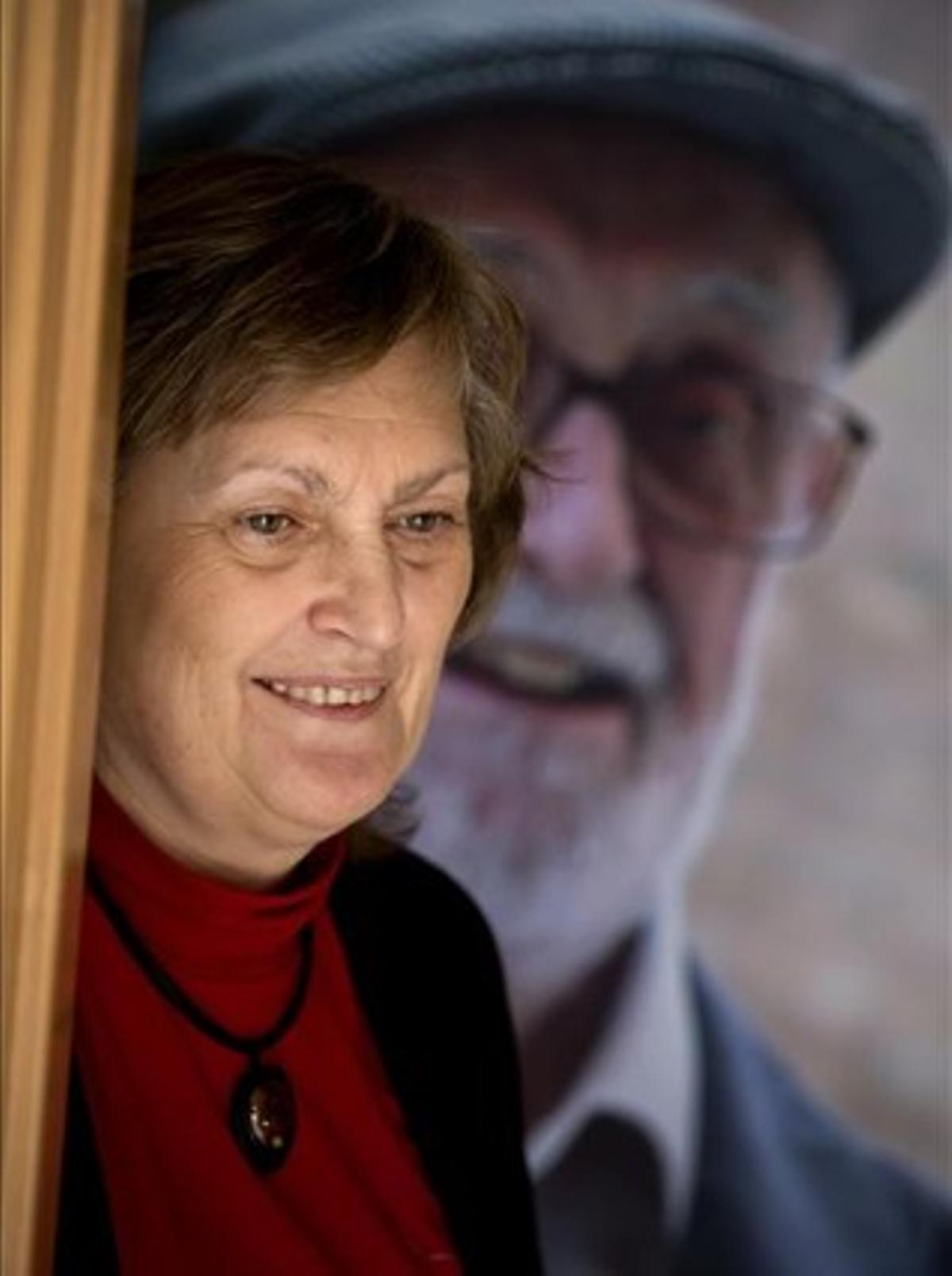 Olga Lucas, en su casa, ante un retrato de José Luis Sampedro.