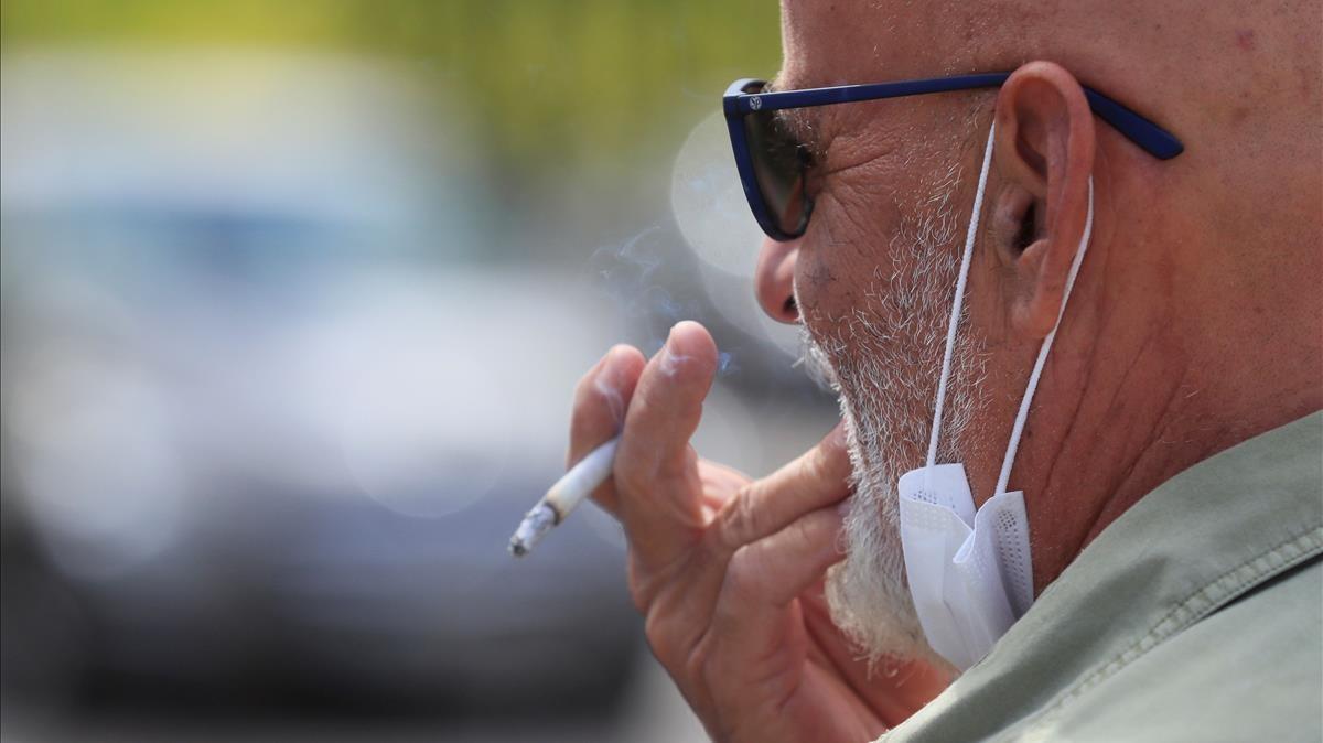 Un hombre fumando en la calle. Un hombre fumando en la calle.