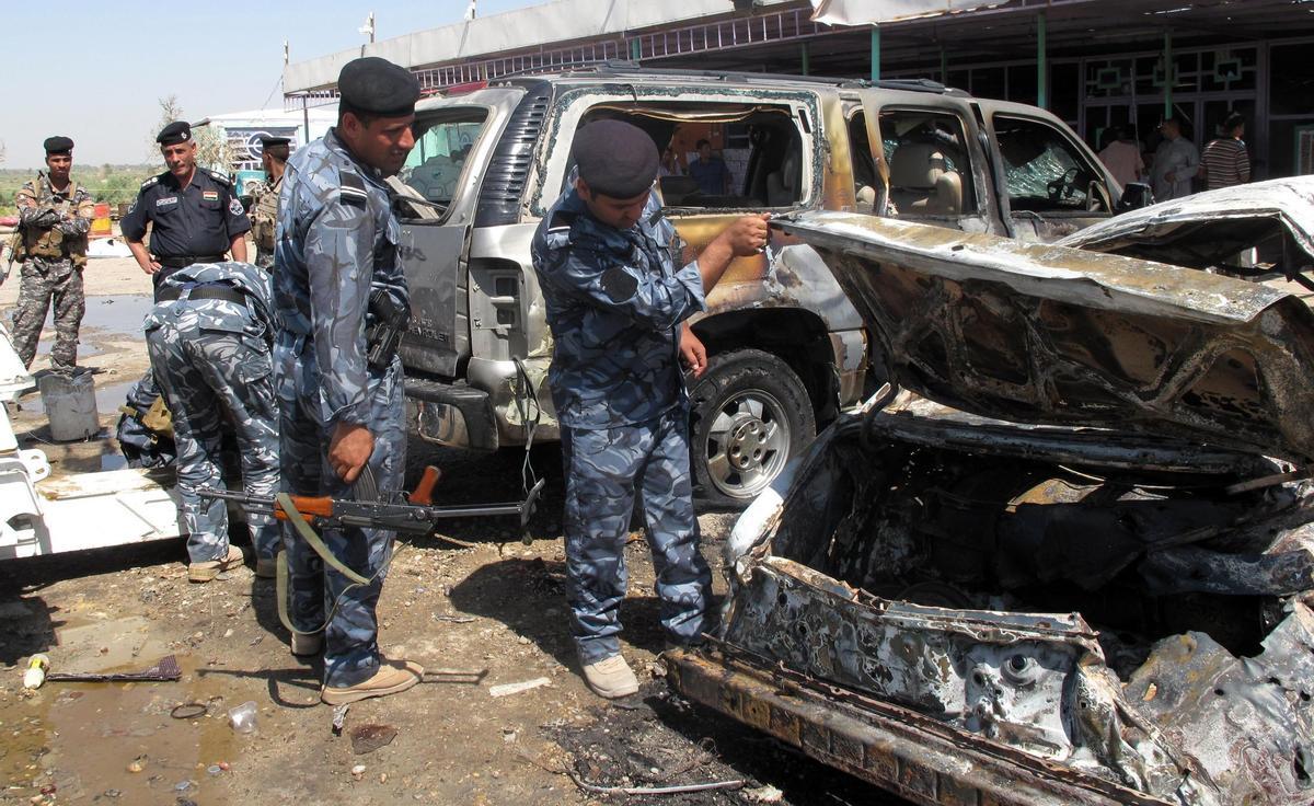 Policías iraquíes inspeccionan el sitio de un ataque con bomba.