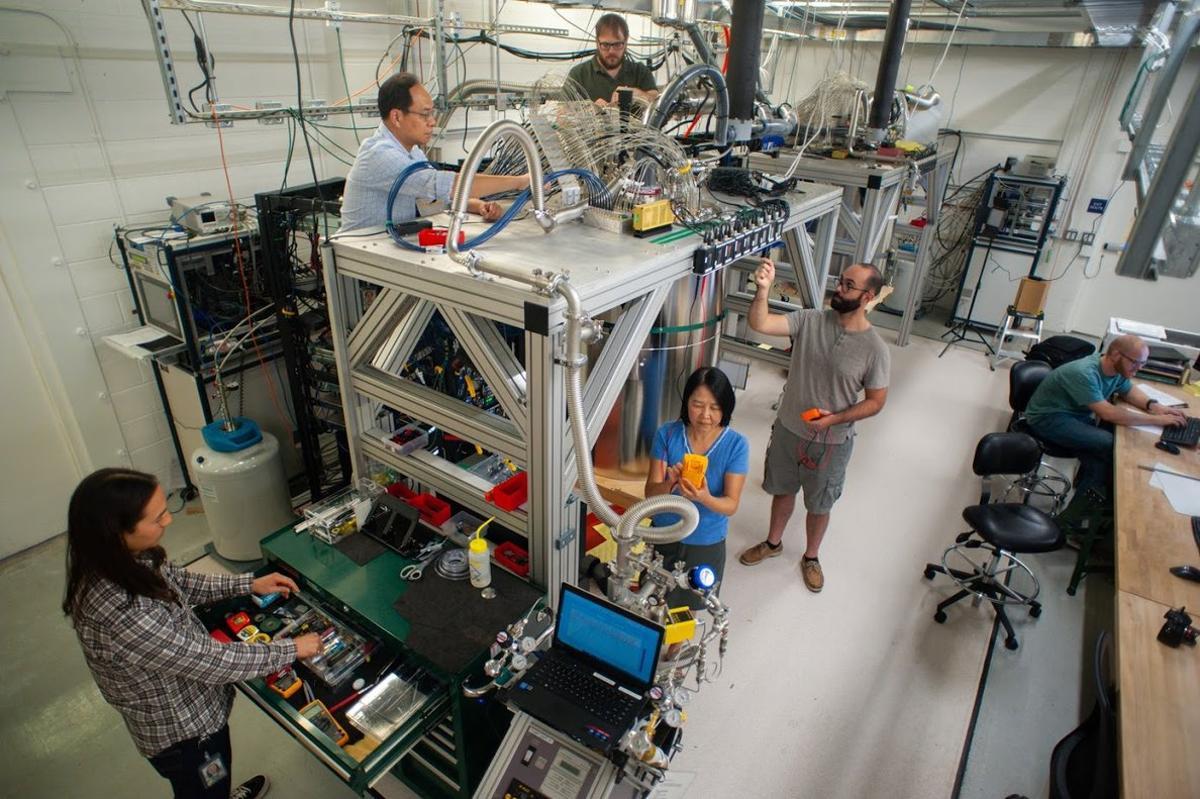 Científicos e ingenieros de Google alrededor de la cámara de refrigeración que contiene el chip del ordenador cuántico más potente de la empresa.