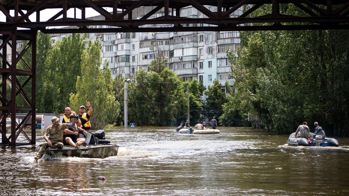 Ciudadanos de Jersón se mueven en lanchas por las calles inundadas por la destrucción de la presa de Novo Kajovka